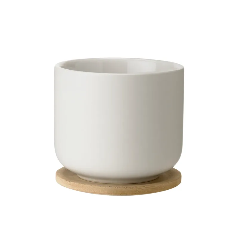 Theo Becher mit Untersetzer Sand von Stelton – Produktfoto